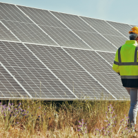 Workers in high-vis walking through field with solar panels