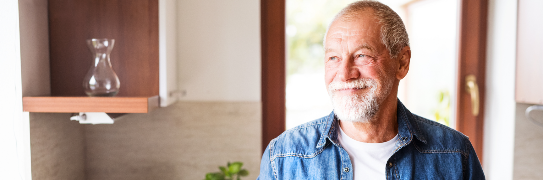 Man smiling standing in his kitchen