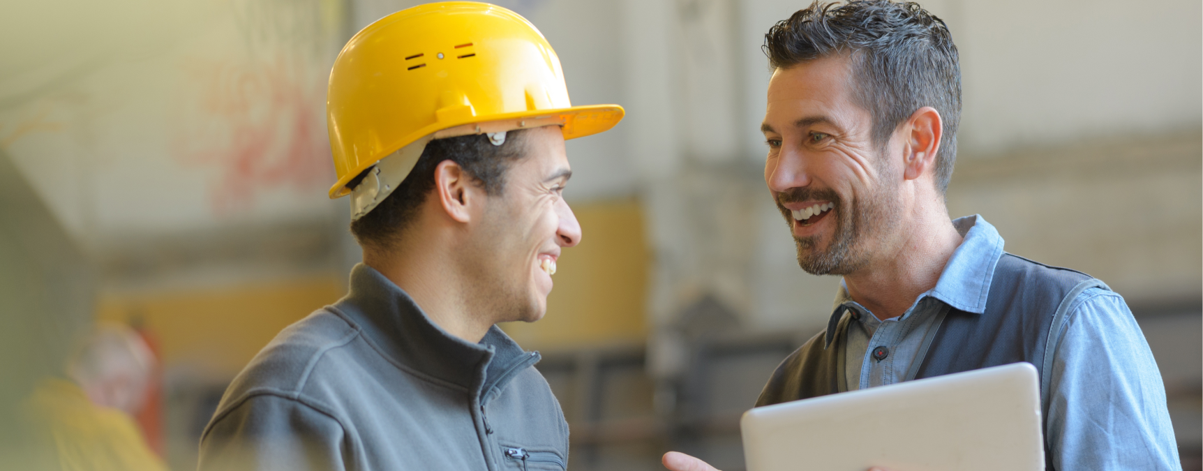 Two men chatting in hard hats